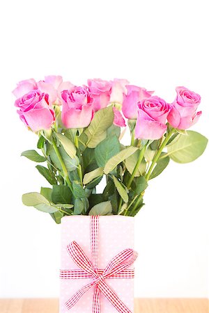 simsearch:400-06877837,k - Bouquet of pink roses with pink gift on wooden table on white background Stock Photo - Budget Royalty-Free & Subscription, Code: 400-06877337