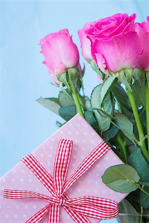 simsearch:400-06877945,k - Bouquet of pink roses in vase with pink gift on blue background Stock Photo - Budget Royalty-Free & Subscription, Code: 400-06877338