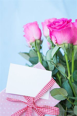 simsearch:400-06877837,k - Bouquet of pink roses in vase with pink gift and blank card on blue background Stock Photo - Budget Royalty-Free & Subscription, Code: 400-06877340