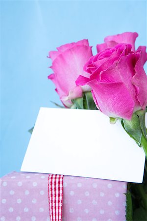 simsearch:400-06877837,k - Bouquet of pink roses in vase with pink gift and blank card on blue background Stock Photo - Budget Royalty-Free & Subscription, Code: 400-06877342