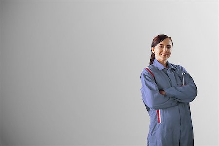 Smiling mechanic standing in front of a grey background Stockbilder - Microstock & Abonnement, Bildnummer: 400-06877613