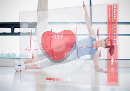 Young woman doing yoga while looking at futuristic interface showing her heartbeat Stock Photo - Budget Royalty-Free & Subscription, Code: 400-06877659