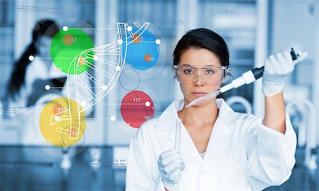 Serious chemist working with colourful dna helix diagram inteface in the lab Stock Photo - Budget Royalty-Free & Subscription, Code: 400-06877749