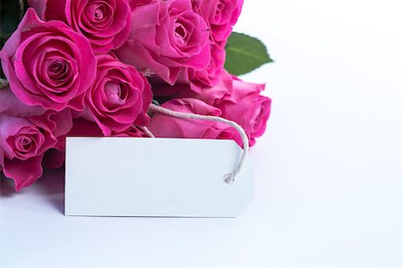 simsearch:400-06877837,k - Bouquet of beautiful pink roses with an empty card on a white table Stock Photo - Budget Royalty-Free & Subscription, Code: 400-06877839