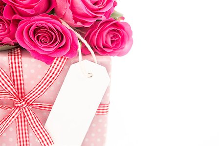 simsearch:400-06877837,k - Close up of a bouquet of pink roses next to a pink gift with a blank card on a white background close up Stock Photo - Budget Royalty-Free & Subscription, Code: 400-06877943