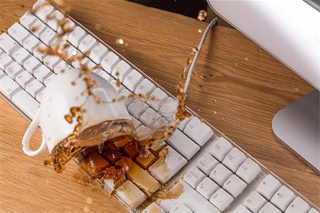 spilt coffee - Cup of tea spilled  over a keyboard on a wooden desk Stock Photo - Budget Royalty-Free & Subscription, Code: 400-06878169