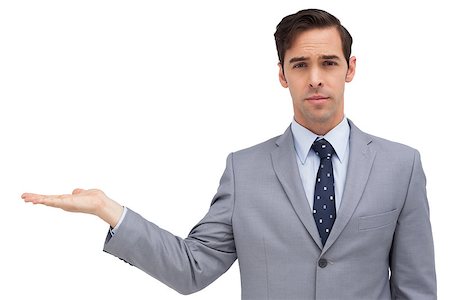 simsearch:400-07275251,k - Serious businessman with open hand looking at the camera against white background Stock Photo - Budget Royalty-Free & Subscription, Code: 400-06879063
