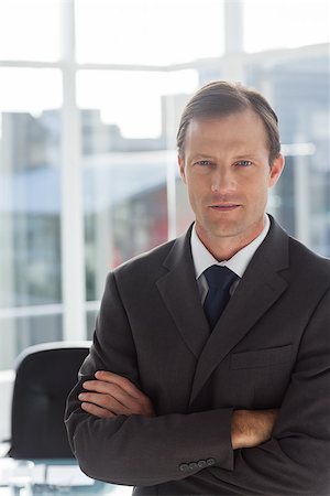 simsearch:400-07275251,k - Confident businessman with arms folded in his office Stock Photo - Budget Royalty-Free & Subscription, Code: 400-06879255