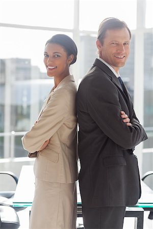 simsearch:400-06879270,k - Smiling business people standing back to back in an office Stock Photo - Budget Royalty-Free & Subscription, Code: 400-06879268