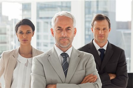 simsearch:400-06879270,k - Serious businessman standing with colleagues behind with arms folded Stock Photo - Budget Royalty-Free & Subscription, Code: 400-06879269