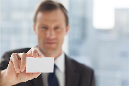 simsearch:400-06879262,k - Businessman showing business card in his office Stock Photo - Budget Royalty-Free & Subscription, Code: 400-06879262