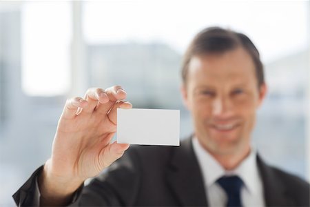simsearch:400-06879262,k - Smiling businessman showing business card in his office Stock Photo - Budget Royalty-Free & Subscription, Code: 400-06879263