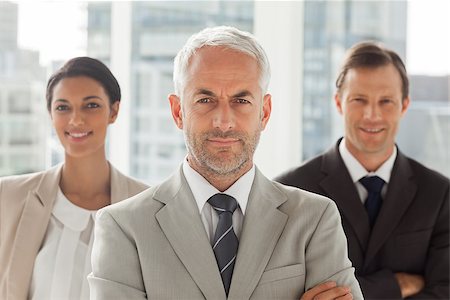 simsearch:400-06879270,k - Businessman standing with colleagues behind with arms crossed Stock Photo - Budget Royalty-Free & Subscription, Code: 400-06879270