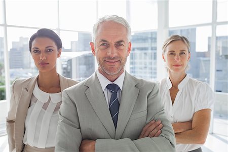 simsearch:400-06879270,k - Confident businessman standing in front of colleagues with arms folded Stock Photo - Budget Royalty-Free & Subscription, Code: 400-06879289