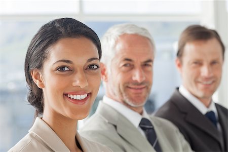simsearch:400-06879270,k - Cheerful businesswoman smiling with colleagues behind standing together in their office Stock Photo - Budget Royalty-Free & Subscription, Code: 400-06879281
