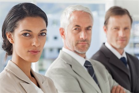 simsearch:400-06879270,k - Serious businesswoman smiling with colleagues behind standing together Stock Photo - Budget Royalty-Free & Subscription, Code: 400-06879282
