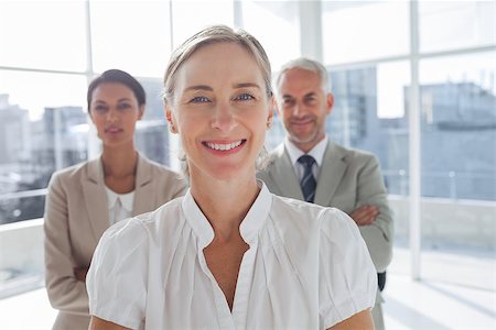 simsearch:400-06879270,k - Smiling businesswoman standing in front of colleagues with arms crossed Stock Photo - Budget Royalty-Free & Subscription, Code: 400-06879292