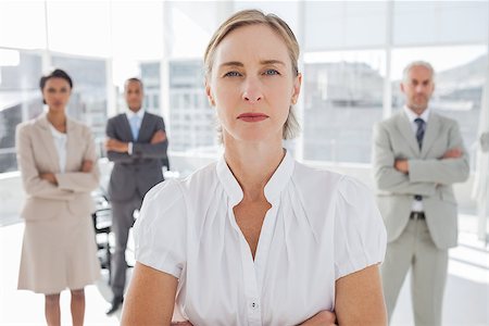 simsearch:400-06879270,k - Serious businesswoman standing with arms folded with colleagues behind Stock Photo - Budget Royalty-Free & Subscription, Code: 400-06879329