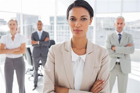 simsearch:400-06879270,k - Attractive serious businesswoman with arms crossed standing in front of colleagues Stock Photo - Budget Royalty-Free & Subscription, Code: 400-06879331