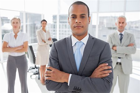 simsearch:400-06879270,k - Serious businessman standing with arms crossed in front of colleagues Stock Photo - Budget Royalty-Free & Subscription, Code: 400-06879333