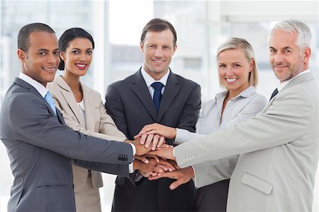 pile hands bussiness - Group of smiling business people piling up their hands together in the workplace Stock Photo - Budget Royalty-Free & Subscription, Code: 400-06879344
