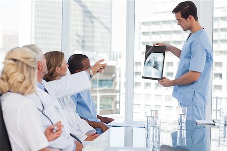 Doctor presenting a radiography to his team in a meeting room Stock Photo - Budget Royalty-Free & Subscription, Code: 400-06879436