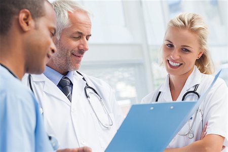 examination folder - Three doctors examining a file and talking about it together Stock Photo - Budget Royalty-Free & Subscription, Code: 400-06879477