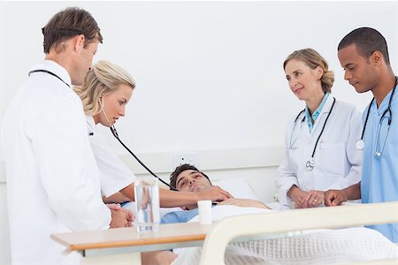 Medical team taking the heartbeat of a patient lying in his bed Stock Photo - Budget Royalty-Free & Subscription, Code: 400-06879501