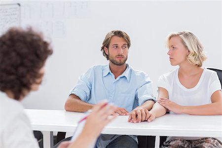 Couple looking doubtful during therapy session as therapist is gesturing at them Stock Photo - Budget Royalty-Free & Subscription, Code: 400-06879615