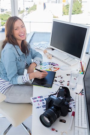 editor (female) - Laughing photo editor working with a graphic tablet at her desk with camera and contact sheets Stock Photo - Budget Royalty-Free & Subscription, Code: 400-06879883