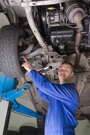 simsearch:400-06870137,k - Portrait of male mechanic examining under vehicle Photographie de stock - Aubaine LD & Abonnement, Code: 400-06870010