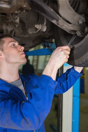 Male mechanic adjusting car tire with spanner Stock Photo - Budget Royalty-Free & Subscription, Code: 400-06870047
