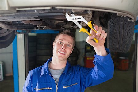 Portrait of auto mechanic repairing car with adjustable pliers Stock Photo - Budget Royalty-Free & Subscription, Code: 400-06870040
