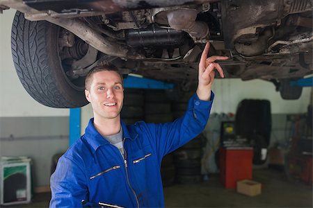 simsearch:400-06870131,k - Portrait of male repairman examining under car in workshop Photographie de stock - Aubaine LD & Abonnement, Code: 400-06870060