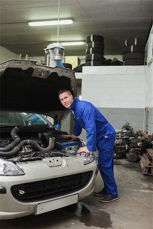 simsearch:400-06870097,k - Portrait of male mechanic examining car engine in workshop Foto de stock - Super Valor sin royalties y Suscripción, Código: 400-06870093
