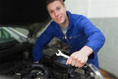 simsearch:400-06870097,k - Portrait of auto mechanic with spanner repairing car Foto de stock - Super Valor sin royalties y Suscripción, Código: 400-06870104