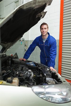 simsearch:400-06870131,k - Portrait of male mechanic standing by car in workshop Photographie de stock - Aubaine LD & Abonnement, Code: 400-06870105