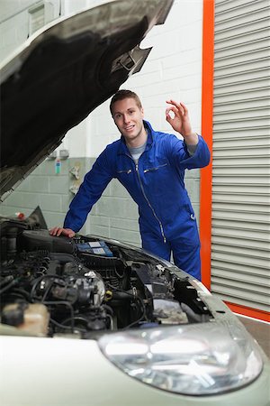 simsearch:400-06878892,k - Portrait of young male mechanic by car making ok sign Photographie de stock - Aubaine LD & Abonnement, Code: 400-06870109
