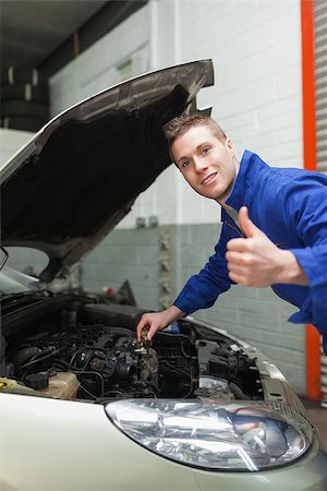 simsearch:400-06878892,k - Portrait of auto mechanic gesturing thumbs up as he checks oil level of car Photographie de stock - Aubaine LD & Abonnement, Code: 400-06870117