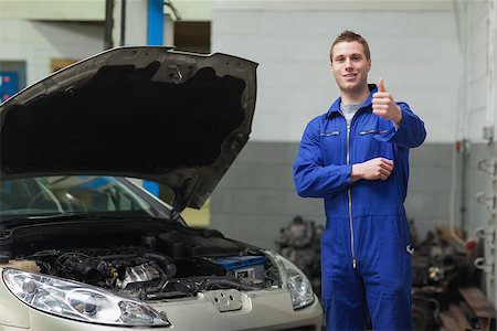 simsearch:400-06878892,k - Portrait of male mechanic by car giving thumbs up gesture Photographie de stock - Aubaine LD & Abonnement, Code: 400-06870125