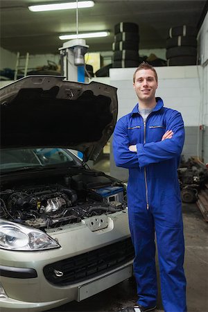simsearch:400-06878892,k - Portrait of young male mechanic with arms crossed standing by breakdown car Photographie de stock - Aubaine LD & Abonnement, Code: 400-06870127