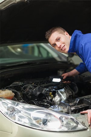 simsearch:400-06870131,k - Portrait of repairman with flash light examining car engine Photographie de stock - Aubaine LD & Abonnement, Code: 400-06870139