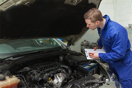 simsearch:400-06870137,k - Male mechanic writing on clipboard while examining car engine Photographie de stock - Aubaine LD & Abonnement, Code: 400-06870146