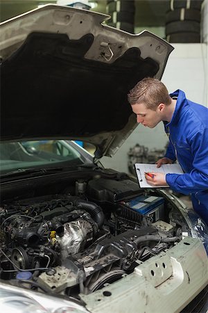 simsearch:400-06870137,k - Auto mechanic writing on clipboard while examining car engine Photographie de stock - Aubaine LD & Abonnement, Code: 400-06870147