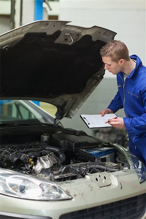 simsearch:400-06870131,k - Male mechanic with clipboard checking car engine Photographie de stock - Aubaine LD & Abonnement, Code: 400-06870141