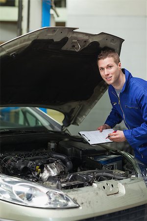 simsearch:400-06870137,k - Portrait of auto mechanic with clipboard inspecting car engine Photographie de stock - Aubaine LD & Abonnement, Code: 400-06870142