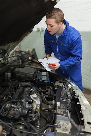 simsearch:400-06870137,k - Mechanic preparing checklist while looking at car engine Photographie de stock - Aubaine LD & Abonnement, Code: 400-06870150
