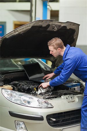 simsearch:400-06870137,k - Auto mechanic with laptop repairing car engine in workshop Photographie de stock - Aubaine LD & Abonnement, Code: 400-06870178