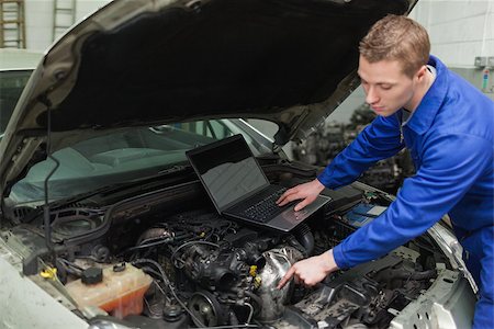 Male mechanic with laptop repairing car engine in workshop Stock Photo - Budget Royalty-Free & Subscription, Code: 400-06870179