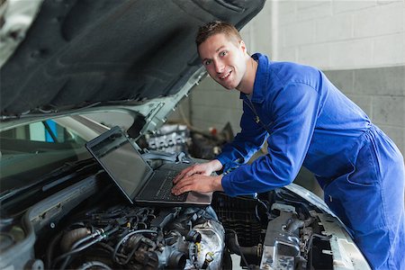 Portrait of happy male auto mechanic using laptop Stock Photo - Budget Royalty-Free & Subscription, Code: 400-06870183